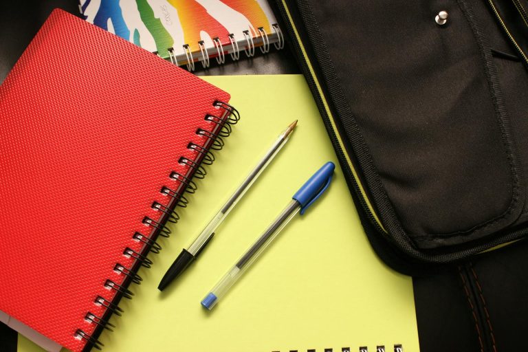 Cahiers colorés et stylos sur un bureau — checklist aménagements scolaires dyslexie PAP PPS