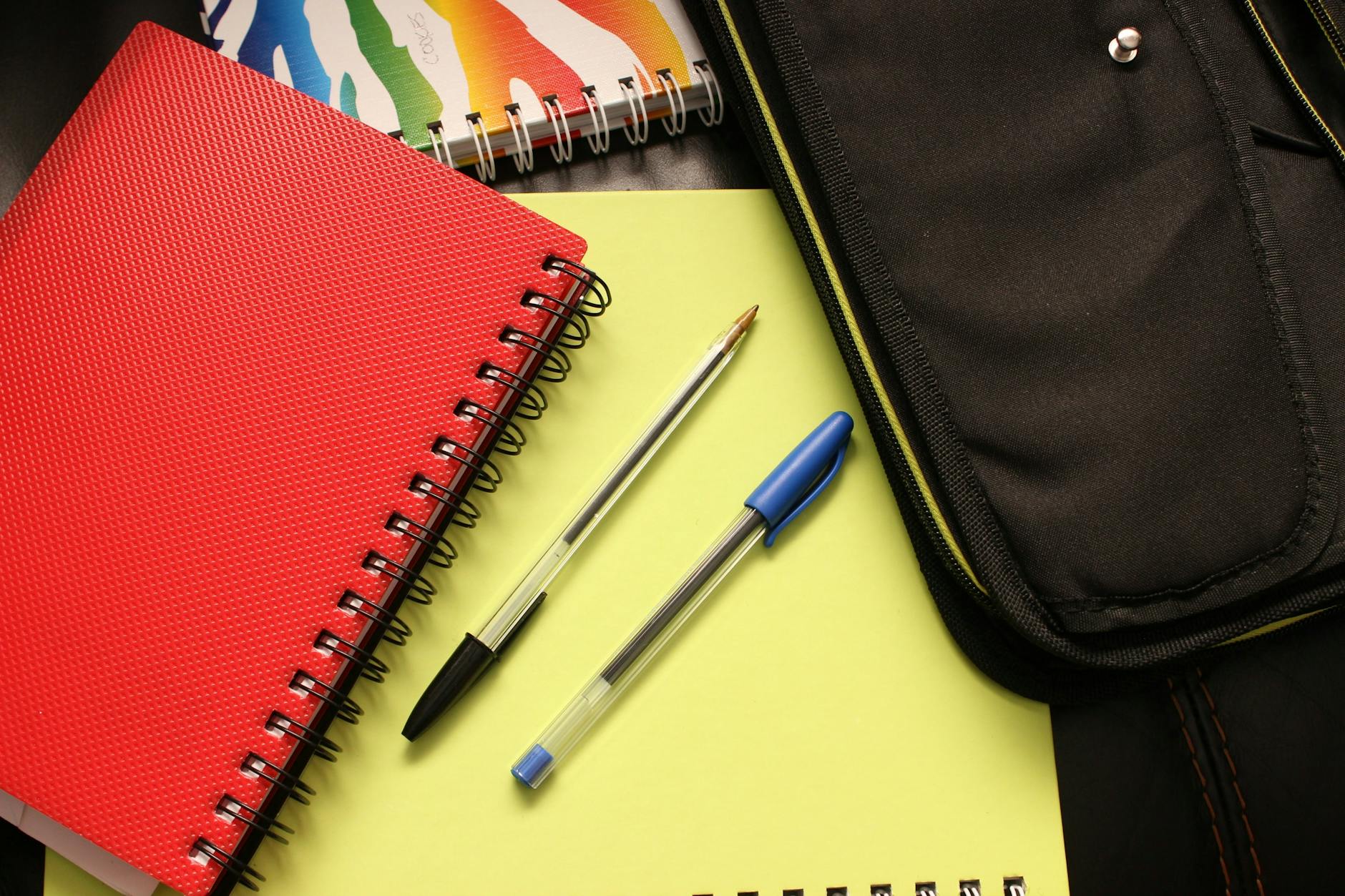 Cahiers colorés et stylos sur un bureau — checklist aménagements scolaires dyslexie PAP PPS