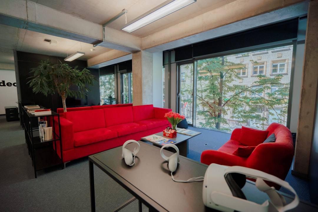a living room with a red couch and headphones on the table